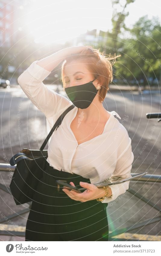 Businesswoman in medical mask in city businesswoman street entrepreneur protect coronavirus tablet sunny female well dressed style elegant formal device