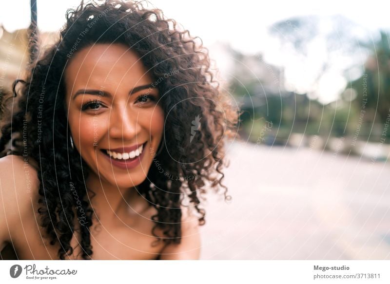 Afro american woman taking a selfie in the city. people afro portrait fun cool smile curly hair style joyful laughing modern outdoor ethnicity stylish cute