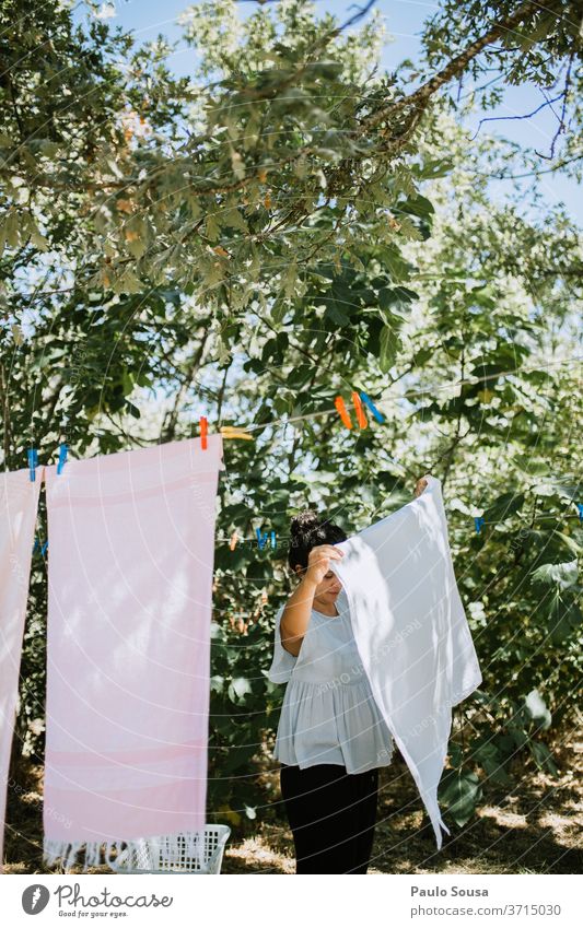Woman hanging clothes on clothesline Clothing Clothesline domestic life Housewife housework Lifestyle Hang up Washing day Housekeeping Clean Living or residing