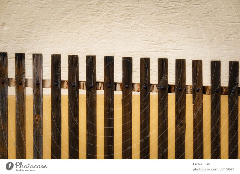 Paling fence straight - dark brown in front of house wall in orange and beige lattice fence laths Brown Beige Orange Wall (barrier) Graphic Everyday Design