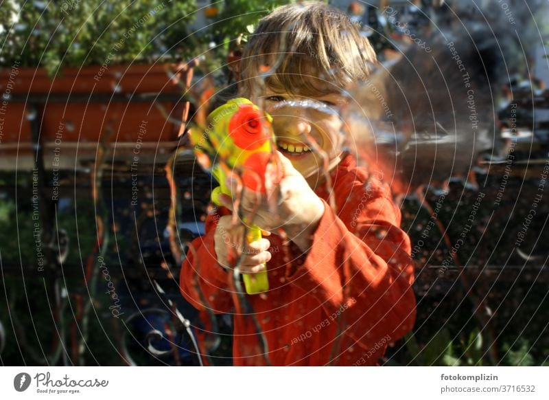 Child with water gun Boy (child) game Playing Happiness fun free time activity Happy Joy Wild Infancy Cheerful Smiling Laughter cheerful Water pistol Grinning