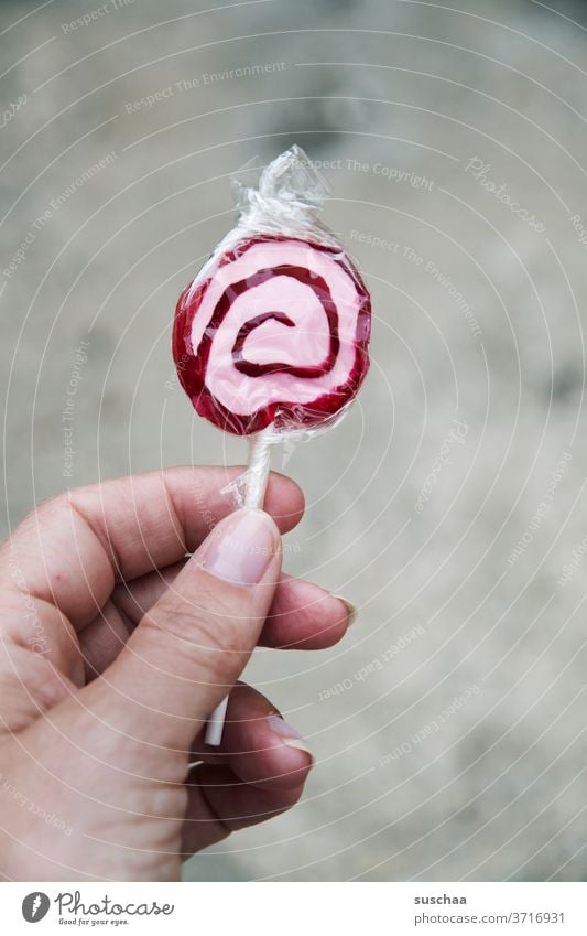 hand holding a lollipop by hand Fingers Woman Sugar Sweet Candy Food Delicious Lollipop Cavities Unhealthy Spiral Tasty Red White