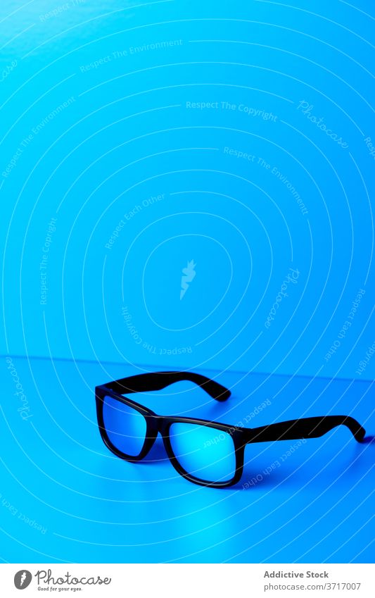 Stylish eyeglasses on blue table style plastic trendy accessory modern studio eyewear creative design fashion bright sunglasses elegant desk minimal simple