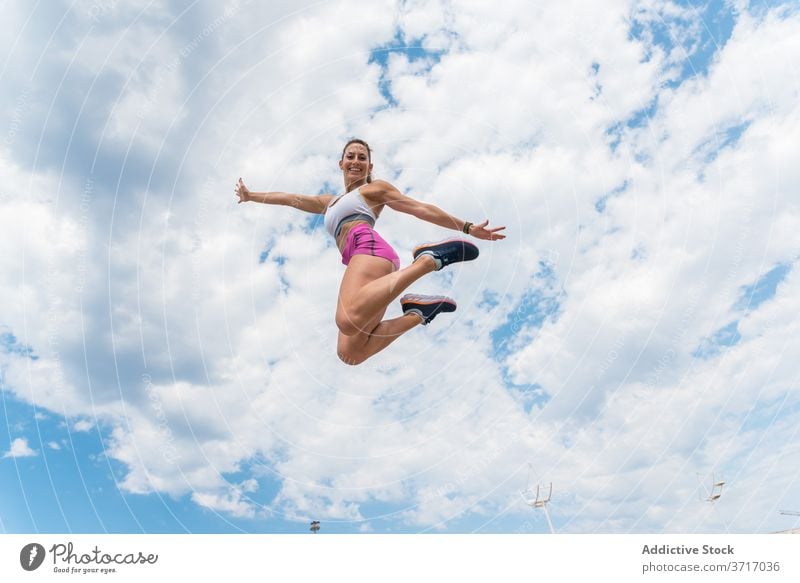 Sportswoman jumping during training sportswoman flexible workout activity intense smile female athlete moment energy healthy exercise slim sportswear