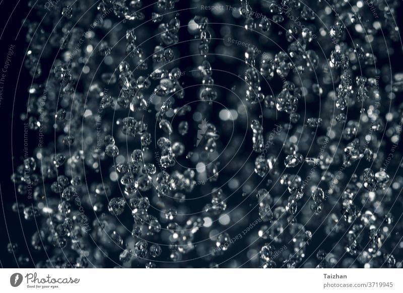 close up rain water drop falling to the floor. Dark mood style . Motion blur , soft focus abstract blue macro natural colours crown flow liquid purity