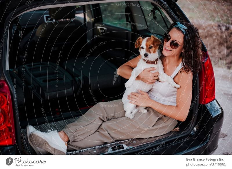 young happy woman in a car enjoying with her cute dog. Travel concept travel jack russell together love outdoors lifestyle friendship vacation animal breed