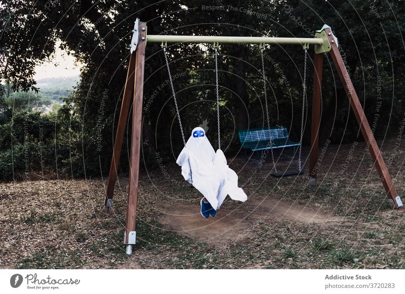 Child in ghost costume in yard halloween child play suit kid playground holiday autumn having fun event scary entertain spooky celebrate season fall creepy
