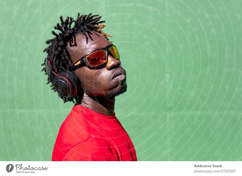 Black sportsman listening to music headphones dreadlocks athlete prepare training enjoy male ethnic black african american healthy gadget summer sportswear
