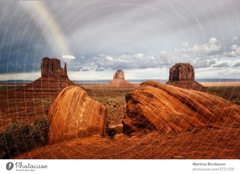 Dark clouds and a rainbow over the Monument Valley, Arizona valley monument usa landscape desert storm park arizona navajo rock red sandstone nature