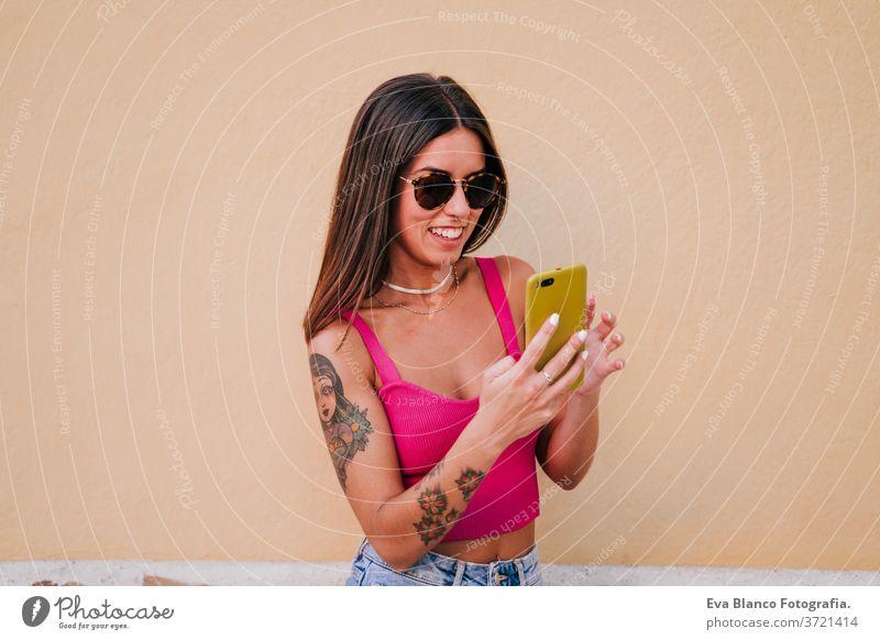 beautiful young woman outdoors using mobile phone. Technology and lifestyle street urban smiling city technology tattoo modern happy summer watching walking