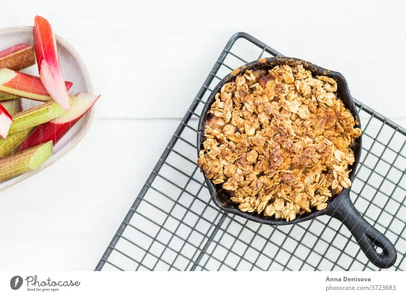 Homemade cooked rhubarb and apple crumble with oatmeal berry healthy fruit cake cobbler food strawberry wooden pan sweet dessert rustic homemade pie cast iron