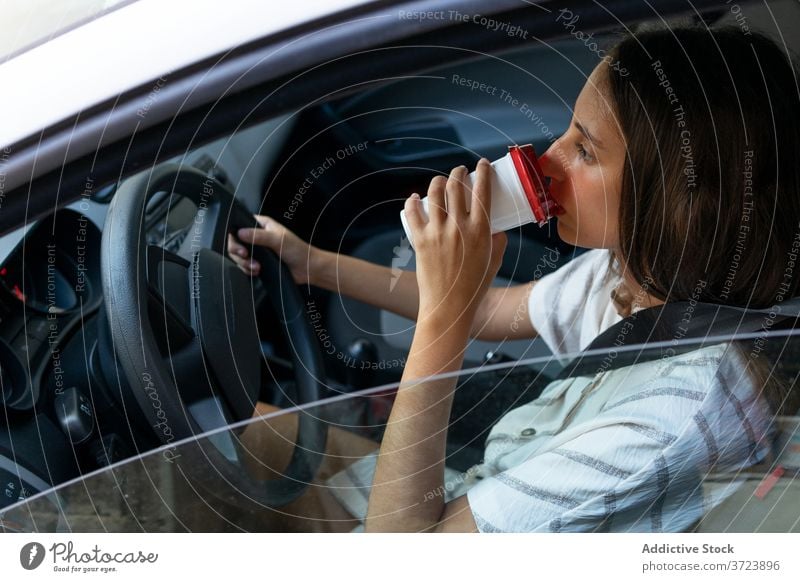 Content woman drinking coffee in car driver commute work morning takeaway female automobile beverage to go cup fresh modern lady transport vehicle refreshment