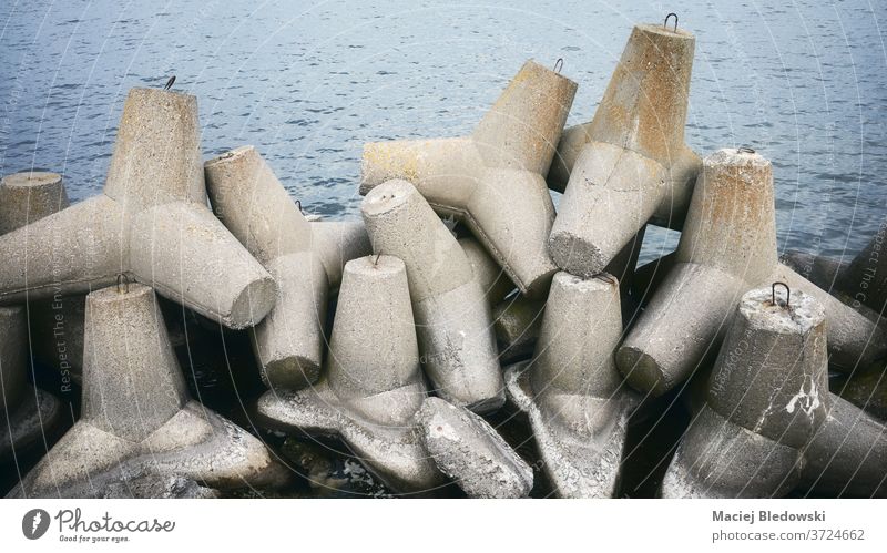 Picture of old coastal concrete breakwater tetrapods. wave safety protect structure strong sea element solid shore seashore ocean reinforcement barrier