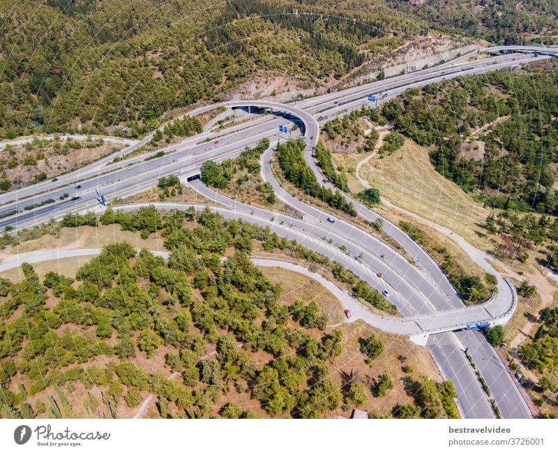 Thessaloniki, Greece aerial drone landscape of interchange traffic on Periferiaki inner ring road. Day top panorama of European multi-level stack highway junction with passing cars through forest.