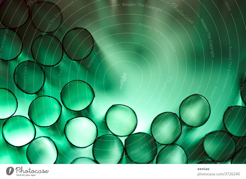 it's green ..ah no it's plastic: green plastic drinking straws with light make black circles with a green background Drinking straws Green Structures and shapes