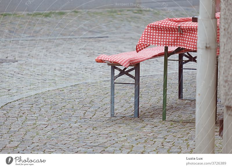 Red and white chequered, beer bench and table at a cobblestone street corner Cobblestones Checkered White Street corner Pattern Colour photo Deserted Day