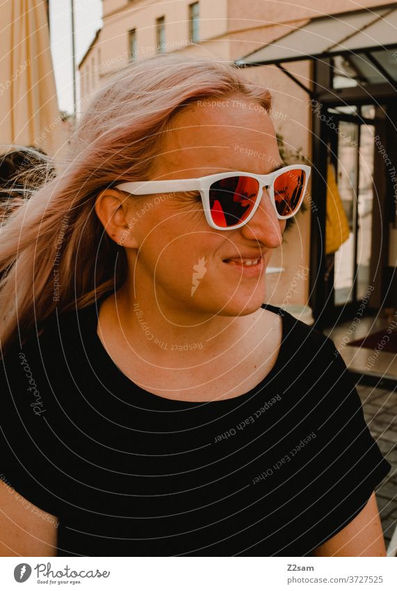 young woman with sunglasses Young woman Blonde pretty Eyeglasses Laughter Smiling fortunate contented T-shirt Black downtown Attractive Happiness Joy portrait