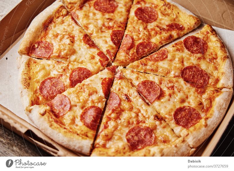 Slice of pizza in cardboard box, closeup slice food unhealthy junk menu background pepperoni cheese table italian sharing cafe share hand family eating lunch
