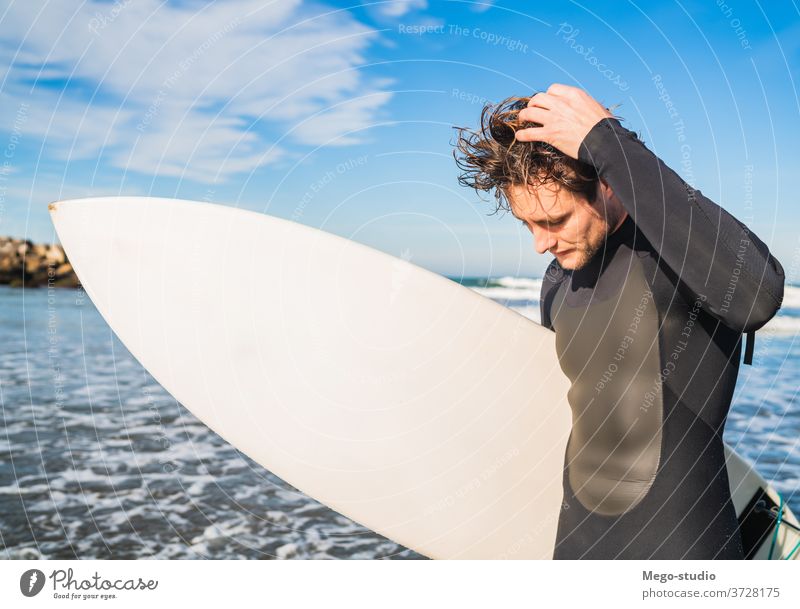 Surfer standing in the ocean with his surfboard. man water sport surfing sea surfer outdoors athletic coastline waves background adventure sports