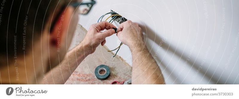 Electrician working on the electrical installation of a house electrician unrecognizable electrical technician connecting wrapping banner web panorama panoramic