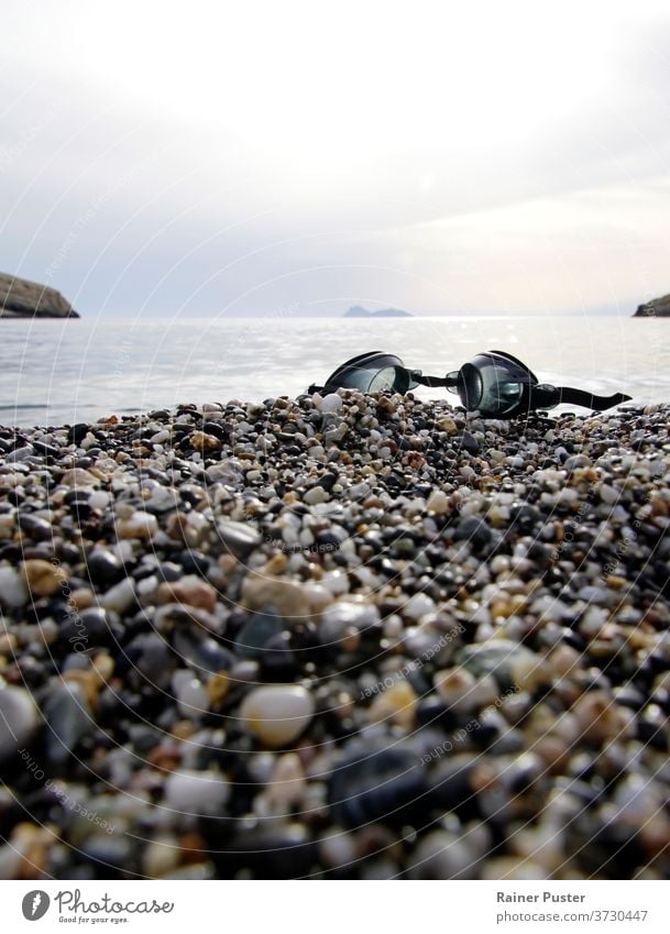Swimming goggles at Matala beach, Crete, Greek coast coastline crete crete greece greek islands landscape matala matala beach outdoor pebble rocks sand sea