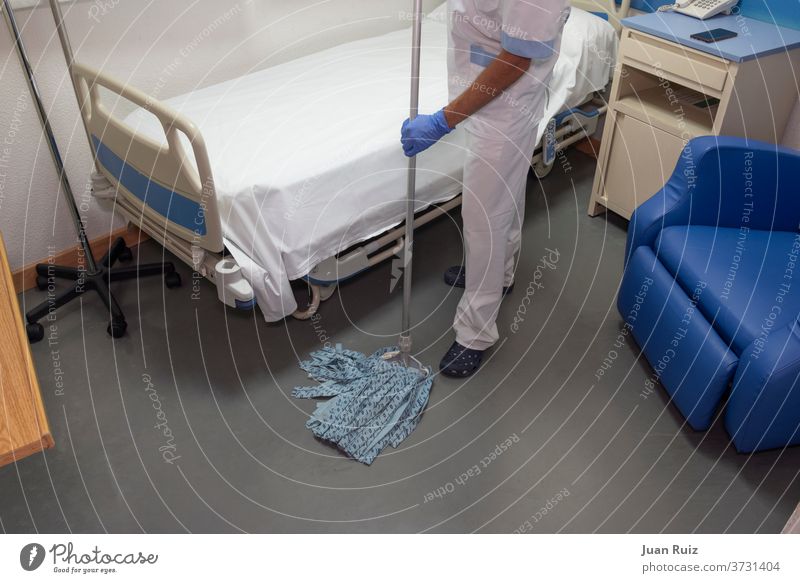 Cleaning staff cleaning hospital rooms medicals men at work career gown workplace health care hygiene upkeep mop glove heavy scrub tied-up dust indoor candid