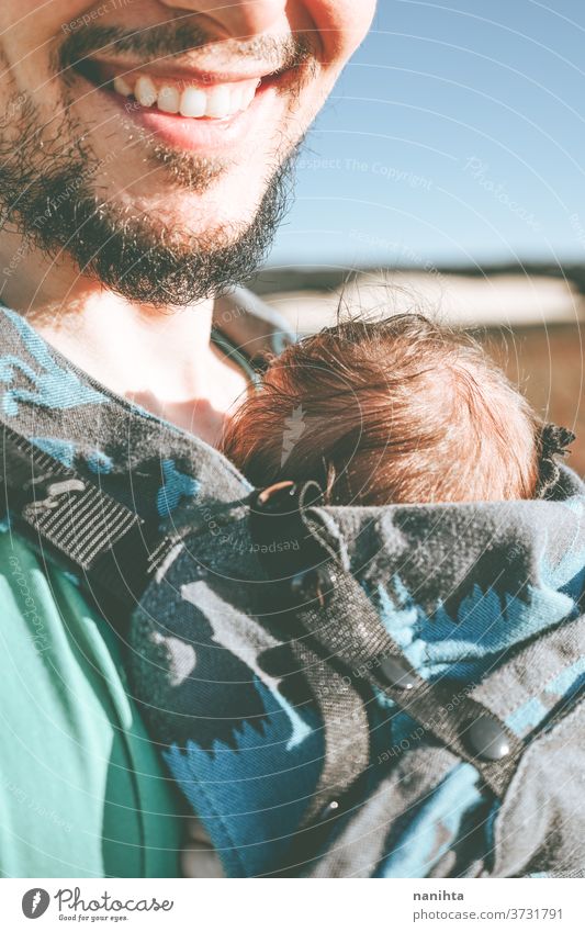 Single male parent carrying her baby with a backpack dad newborn front kangaroo single single parent family outdoors summer fall sunlight take a walk modern