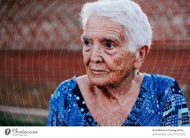 portrait of old lady in her 80s relaxed outdoors woman elderly home garrotte white hair grey hair mental solitude thoughtful grandmother aged health care