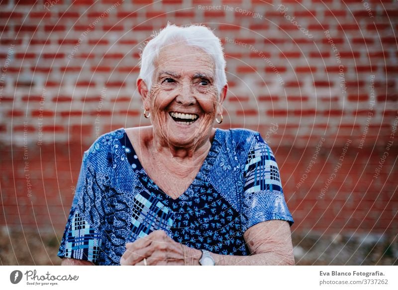 portrait of old lady in her 80s laughing happily happy smiling joy woman elderly home white hair grey hair mental grandmother aged health care looking emotion