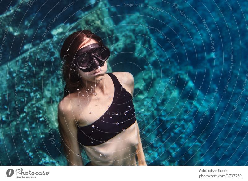 Young woman in diving mask swimming underwater diver goggles snorkel scuba sea ocean young female clean transparent holiday vacation adventure lifestyle