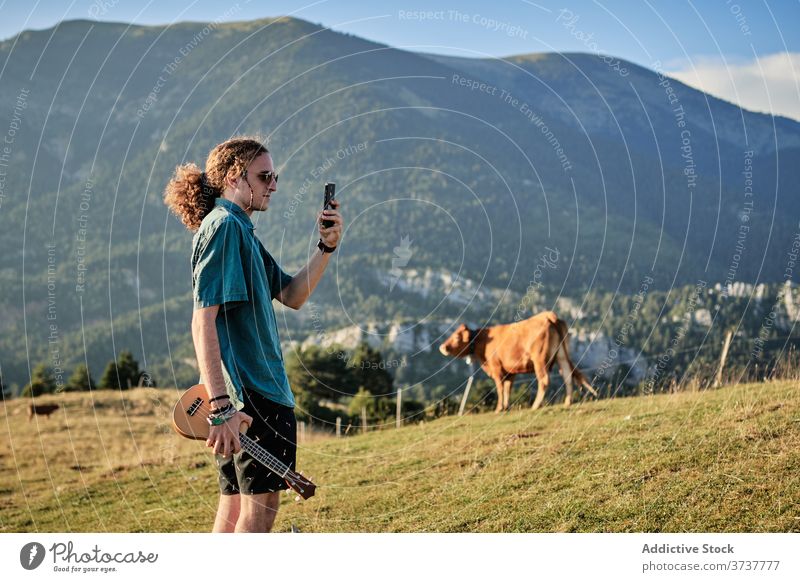 Man taking photo of highland landscape take photo man mountain relax smartphone using memory hipster weekend male scenery ukulele picture amazing hill summer