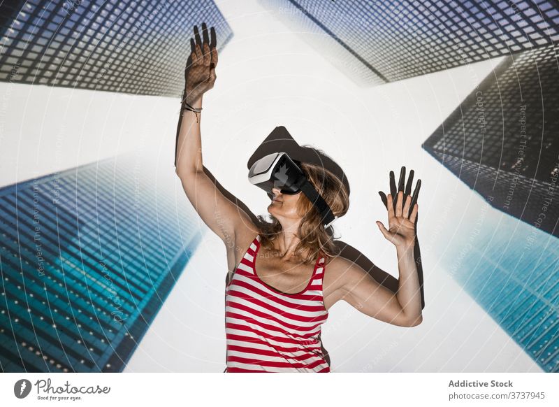 Excited woman in VR headset exploring virtual city vr virtual reality skyscraper building urban goggles touch excited experience effect explore technology