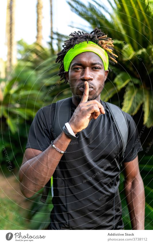 African American sportsman showing silence sign shh gesture silent athlete style sportswear sporty training young african american black ethnic male headband
