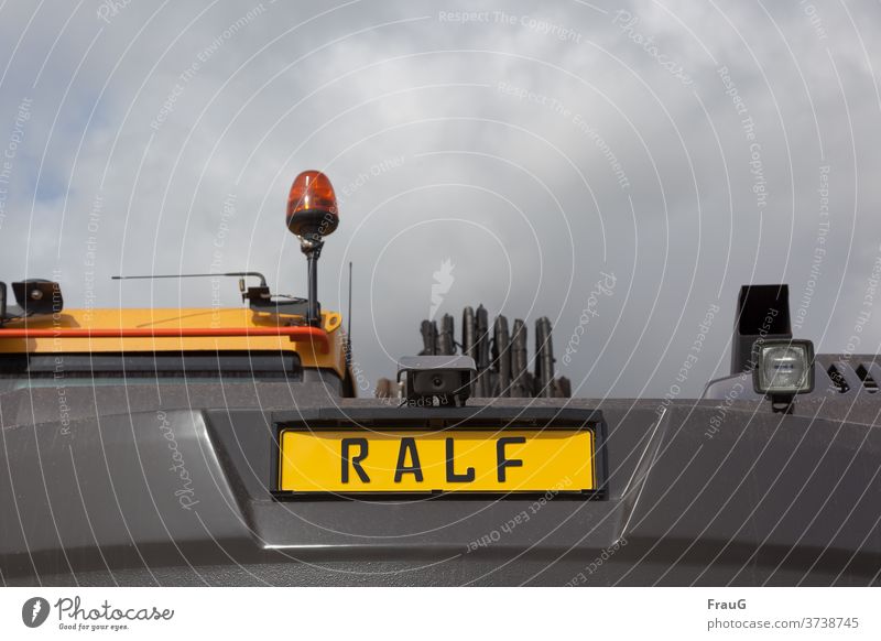 the construction vehicle is called Ralf Construction site Construction site vehicle Name Name plate lamps Rotating beacon Plastic plastic cloudy weather Sky