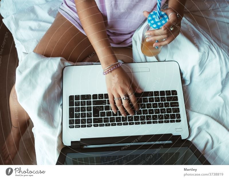 Photo of an an unrecognizable businesswoman sitting in her house working on her computer. Beautiful shot of an unrecognizable person's hands typing on a laptop.