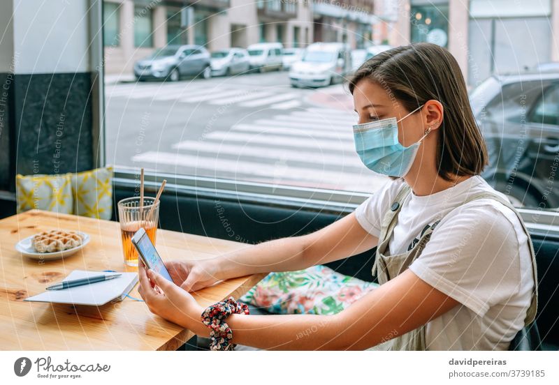 Woman with mask having a snack in a coffee shop cafe woman covid-19 coronavirus protective mask new normal breakfast mobile cafeteria surgical mask girl people