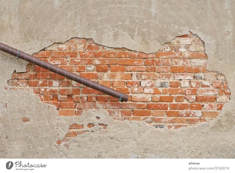 For whatever reason, the sloping downpipe ends halfway up in front of the brick wall, whose sloping plaster exposes the red bricks Downspout bailer Facade