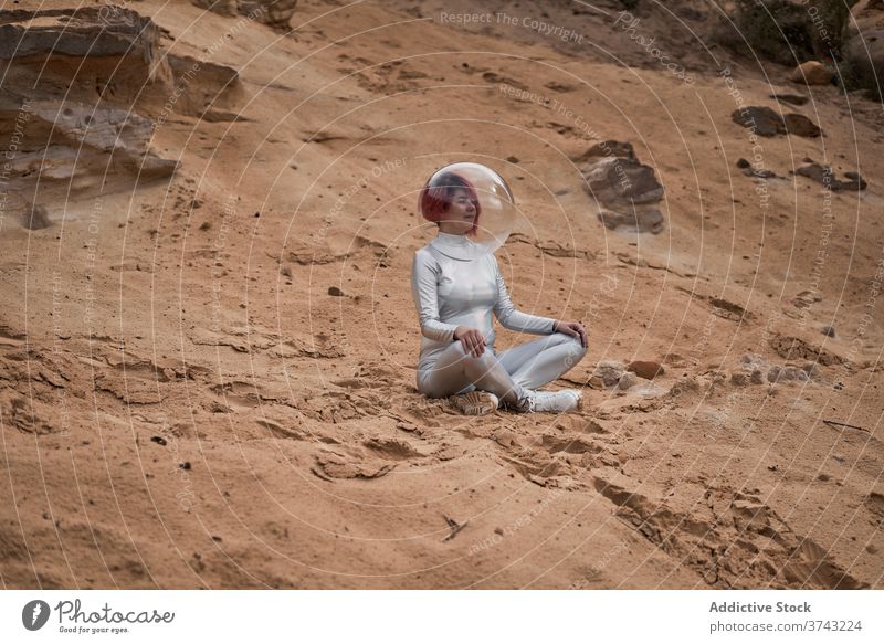 Smiling futuristic woman in sliver suit space astronaut positive young rock stone cosmonaut costume concept female silver helmet smile rest confident happy