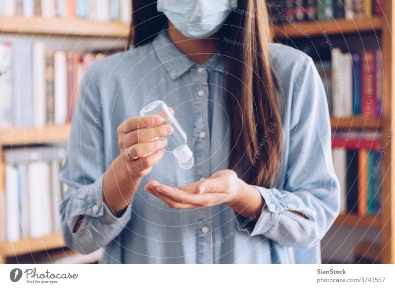 Coronavirus concept. Girl in her home put antiseptic gel on her hands for protection from coronavirus. Global call to stay home. covid quarantine gloves