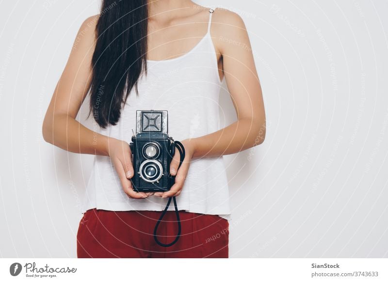 Woman holding a vintage camera front a white background woman isolated retro female photography portrait beautiful lifestyle photographer person attractive