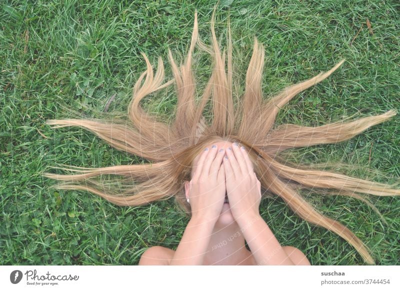 girl lying on a green lawn with hands in front of her face youthful Puberty hair Lawn reclining hands in front of your face Youth (Young adults)