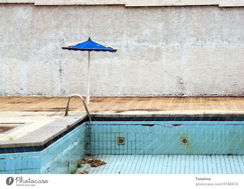 Nobody swims here anymore - or a run-down pool with a broken parasol on a concrete wall lost places Swimming & Bathing Old Deserted Colour photo Day Decline