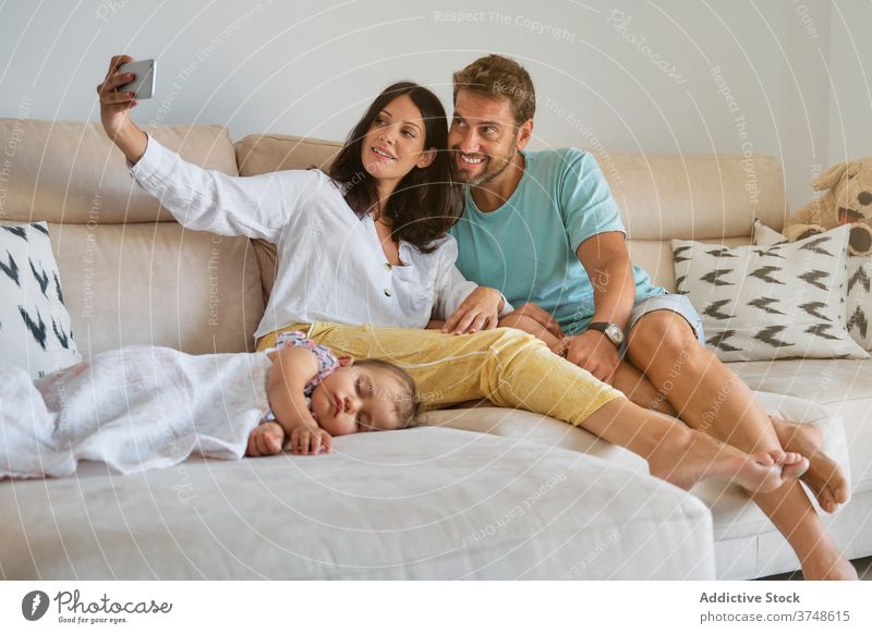Toddler sleeping on the couch while a pregnant couple is making a selfie responsibility memories tenderness unity share tranquility dreaming parenthood newborn