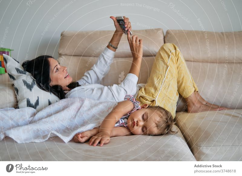 Toddler sleeping with a blanket with her mother making a selfie next to it memories tenderness unity share tranquility dreaming newborn touch safe toddler