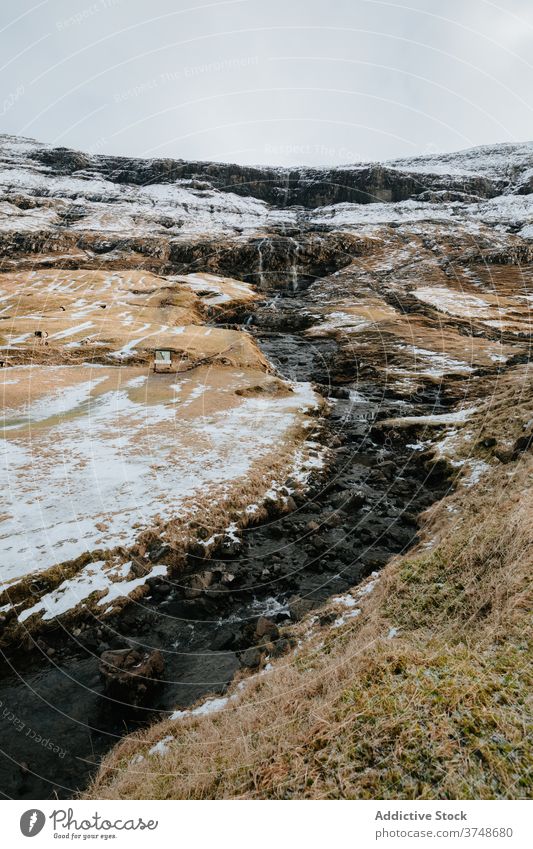 Cold brook in snowy countryside water winter cold overcast sky mountain nature landscape scenic cool flow ridge environment range creek Faroe island cloudy