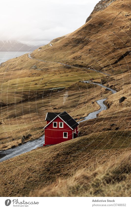 Countryside road and house on seashore cottage countryside clouds sky faroe islands rural landscape nature scenic building hut shack coast travel trip journey