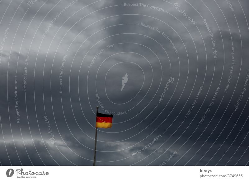 small Germany flag in front of thunderclouds, gloomy scenario, Germany flag German flag German Flag Ensign Politics and state Thunder and lightning Storm clouds