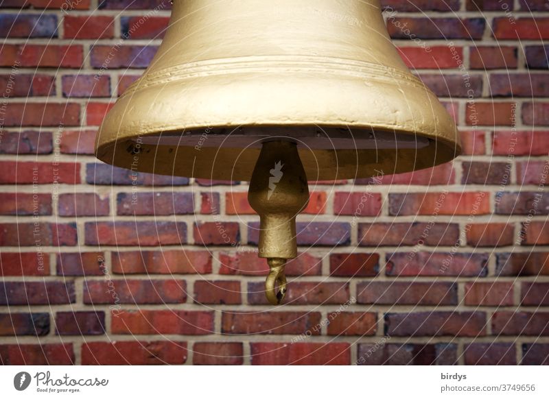 golden bell with clapper, cut in front of a brick wall Bell Gold gold-plated Signal Ship's bell molded Close-up Brick wall Red clappers Bell clapper Loud tone