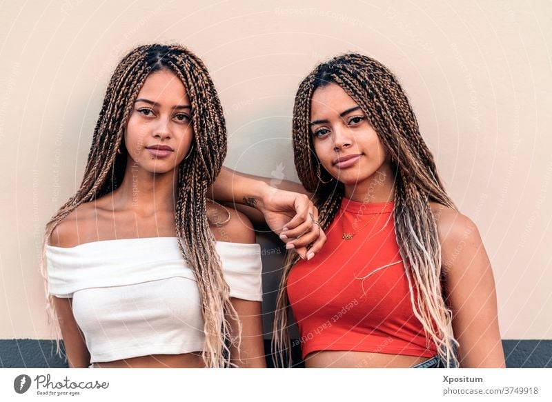 African American Sisters Posing front view sisters african american braids looking at camera street attractive young style expression attitude beautiful pretty