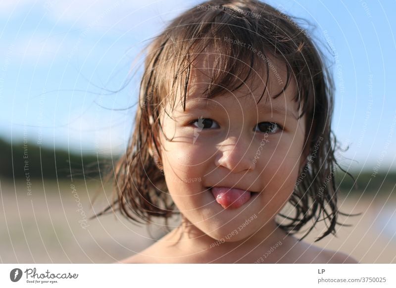 little girl sticking her tongue out Tongue Looking into the camera Upper body Portrait photograph Sunset Sunrise Sunbeam Sunlight Light Copy Space top